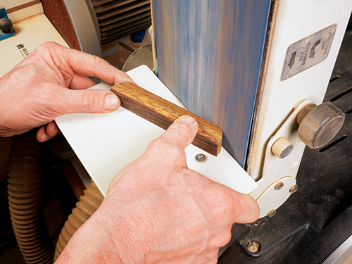 Shaping knife block foot blanks with belt sander