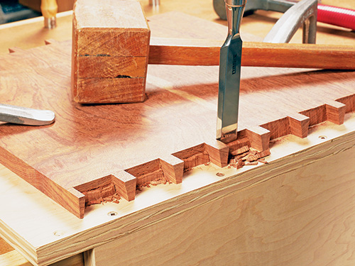 Using chisel to clean out space between dovetail pins